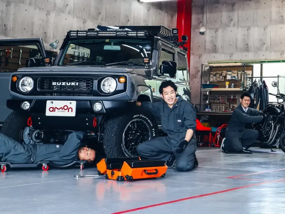 三位技師在車庫用 AMON 工具維護一台 Jimny