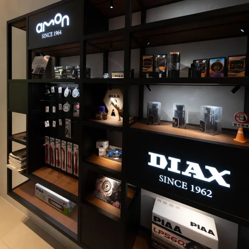紳新國際總部展示間,AMON 與 DIAX 燈箱招牌下陳列三個品牌的商品
